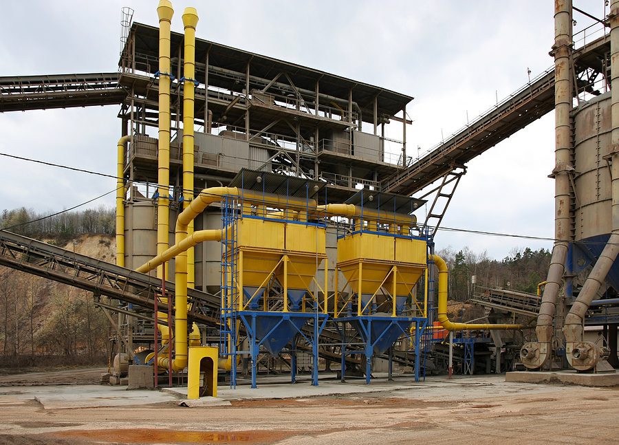 Yellow and blue silo tank storage bins at a stone quarry.